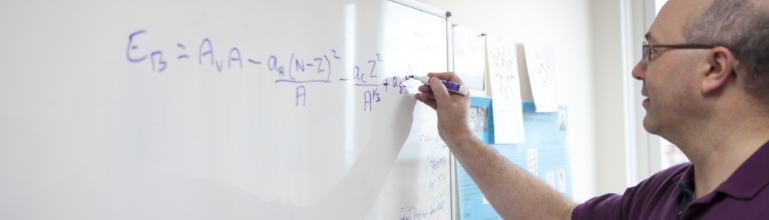 Academic writing equations on a whiteboard. 