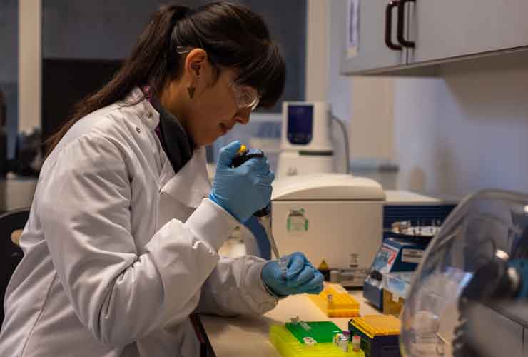 Meg using a pipette in a lab