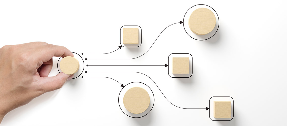 A hand moving wooden shapes around a white background containing a diagram.