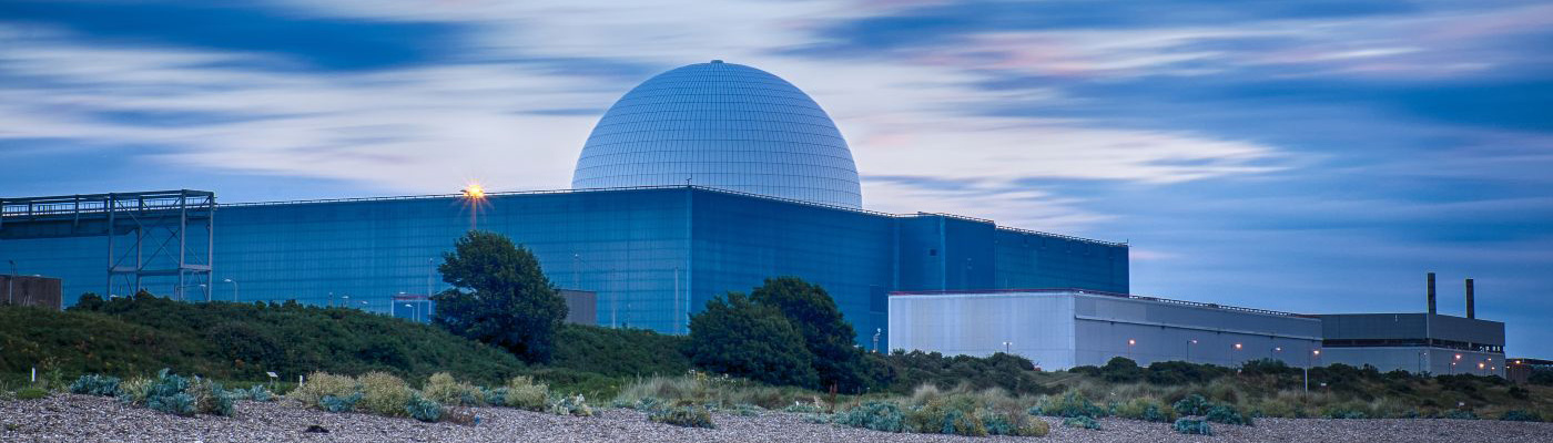 Evening view of a nuclear power station with a pebble beach in the foreground