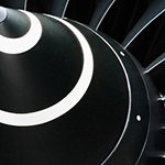 Close-up view of a jet engine turbine with metallic blades arranged in a circular pattern.