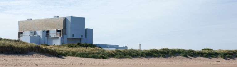 A nuclear plant building next to a beach 