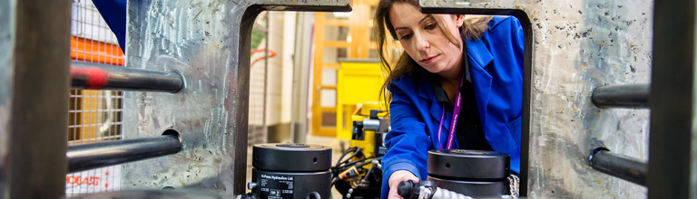 Blue coated researcher focusing on something off camera